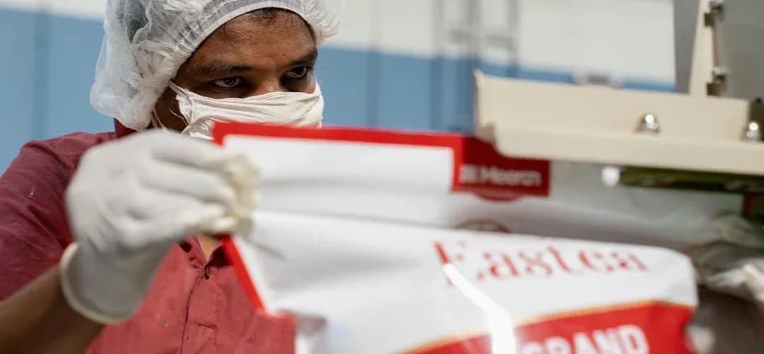 Worker in protective gear inspecting Meeran packaging